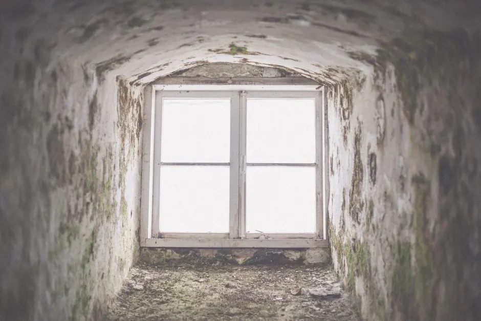 An eerie window framed in a derelict building in Hiiu County, showcasing time's impact.